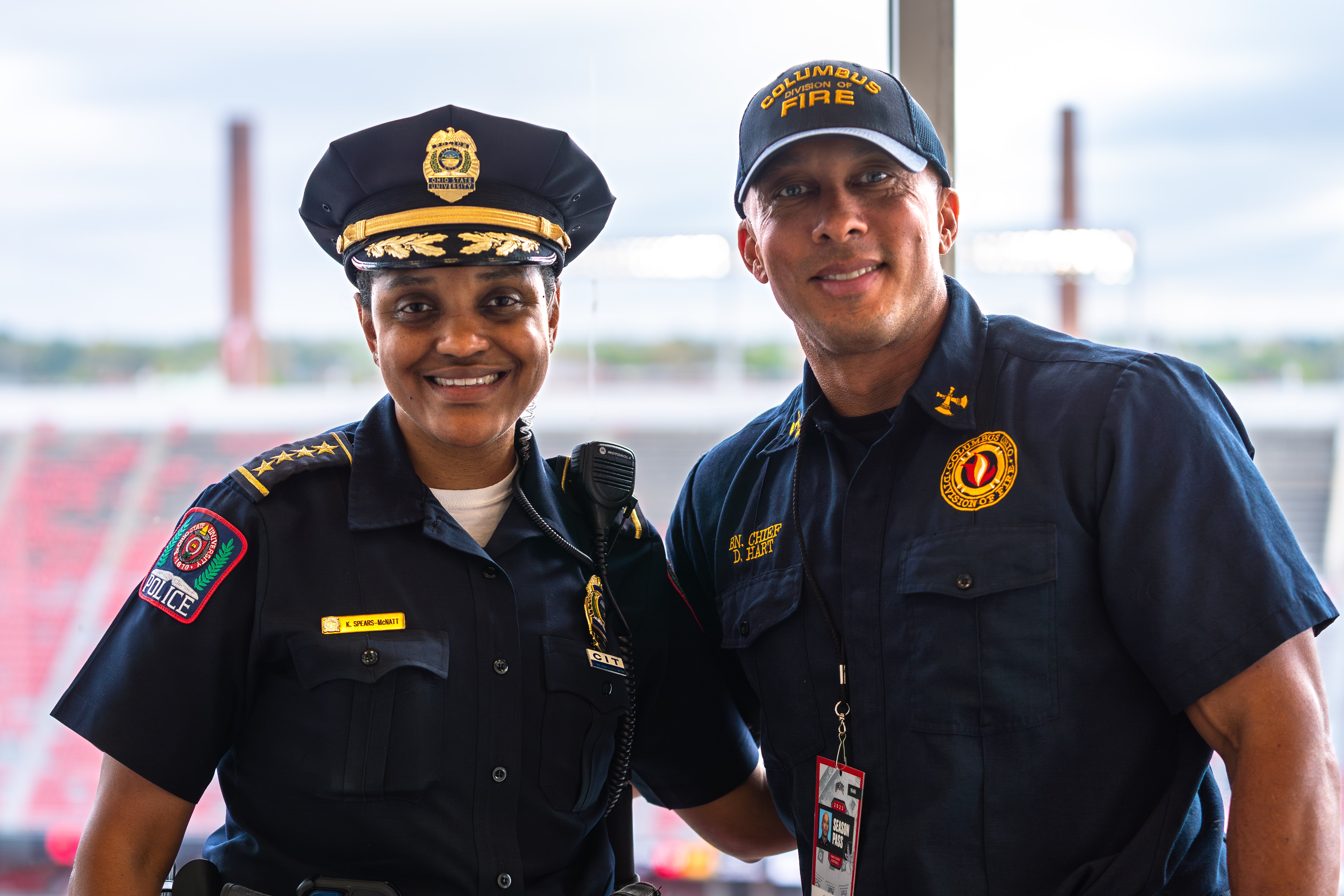 An officer and a firefighter standing together and smiling.