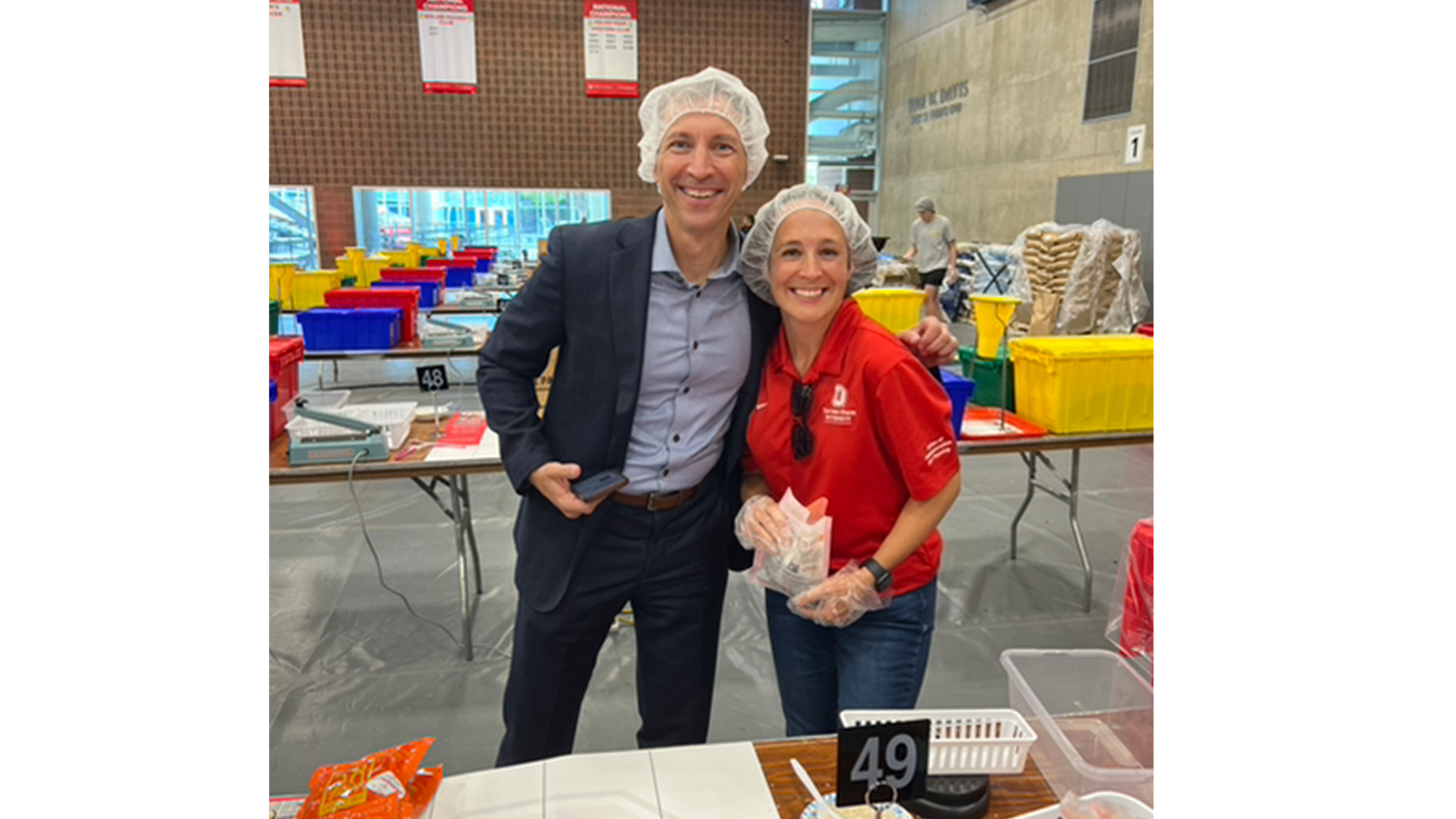 Chris Kabourek and Nicole Holman smile at the camera while at the meal packing event.