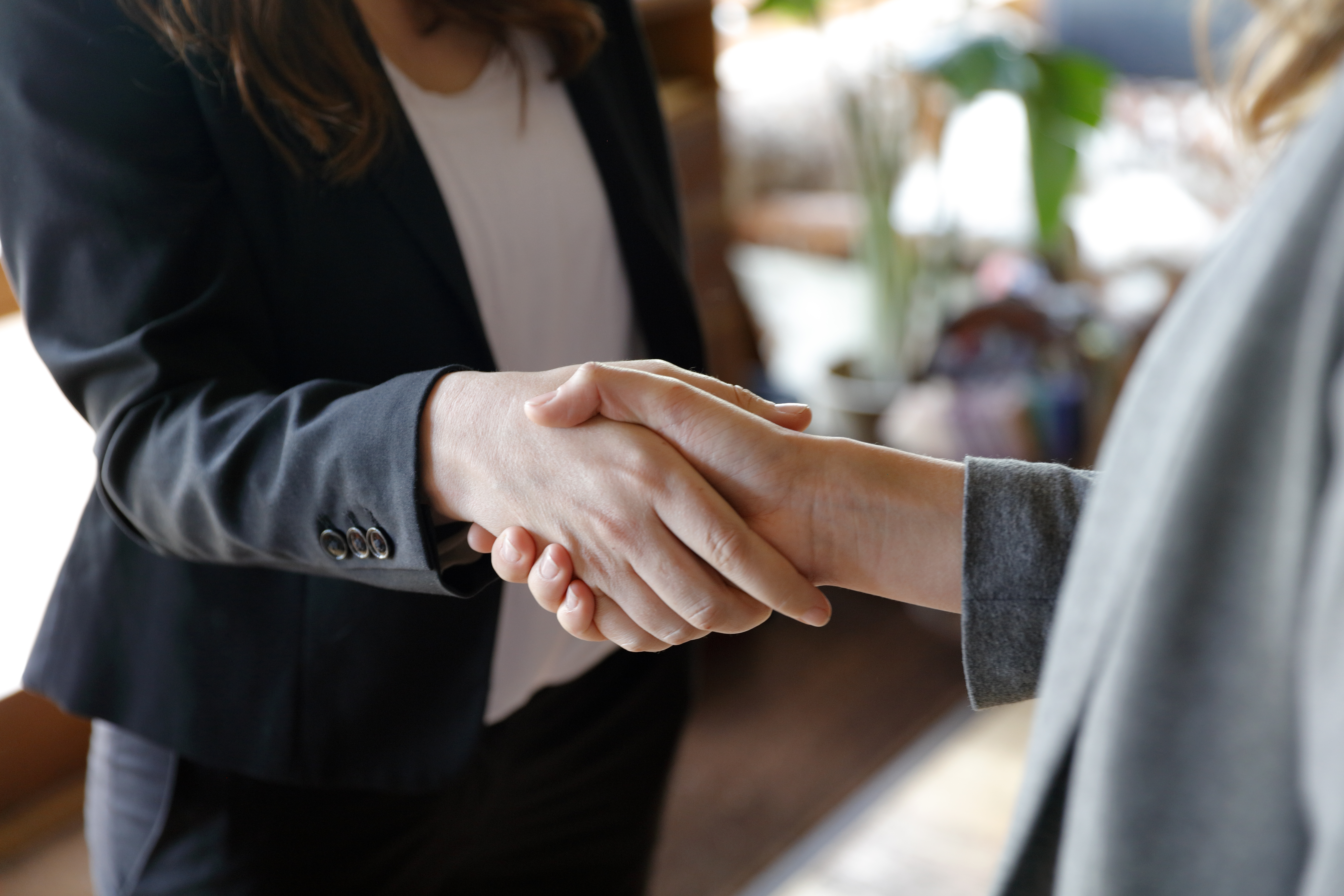 Two women shake hands.