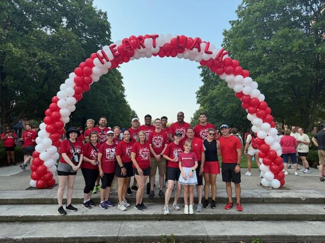 people standing underneath balloon arch