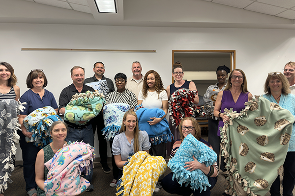 group of people holding fleece blankets